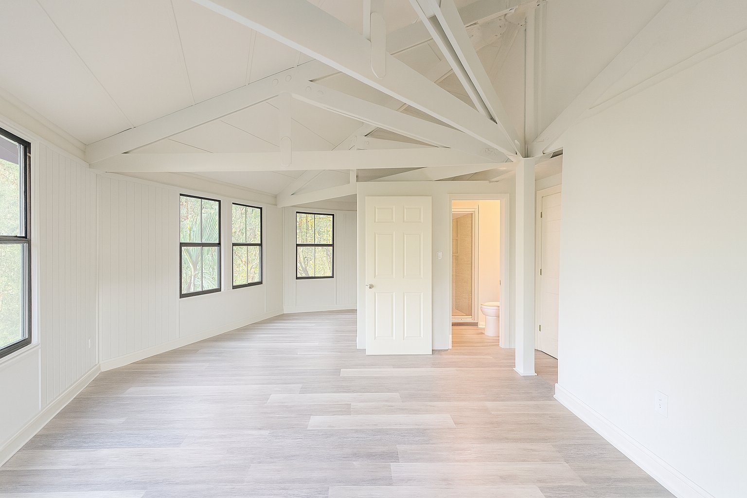 Lake Lofts interior with vaulted ceiling, exposed beams and large windows